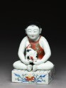 Figure of a boy seated on a shogi, or chess board