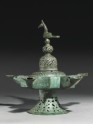 Oil lamp with dome-shaped lid surmounted by a bird