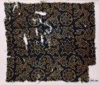 Textile fragment with rosettes or wheel-shapes, flowers, and plants (EA1990.236)