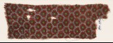 Textile fragment with grid of oval shapes and rosettes