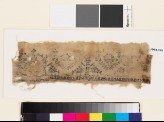 Textile fragment with stylized pairs of birds, trees, and pseudo-kufic inscription (EA1993.177)
