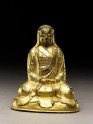 Seated figure of a monk with a robe draped over his head