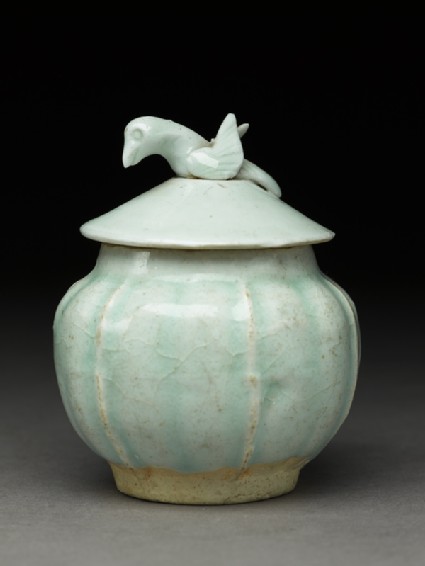 Lidded white ware jar surmounted by birdside