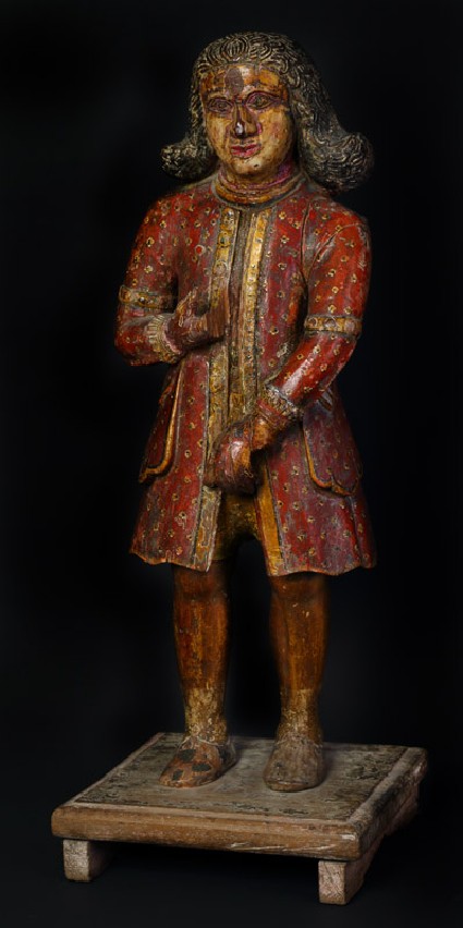 Figure of a standing Dutchman wearing a red coatoblique