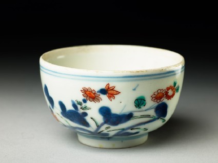 Cup with prunus and flowering plantoblique