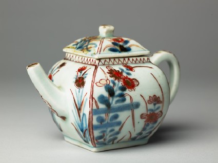Teapot with two types of flowering plantsside