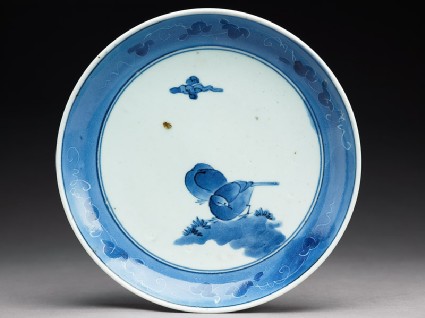 Plate with two birds under a cloudtop