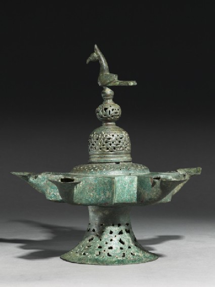 Oil lamp with dome-shaped lid surmounted by a birdside