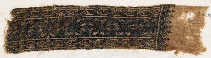 Textile fragment with linked diamond-shapes and stylized vinesfront