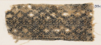 Textile fragment with linked diamond-shapes and interlaced crossesfront
