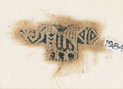 Textile fragment with inscription and an animal, possibly a lionfront