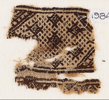 Textile fragment with diamond-shapes against a background of dotsfront