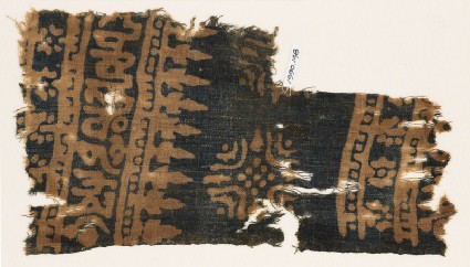 Textile fragment with Arabic-style script, rosettes, and stylized trees or foliagefront