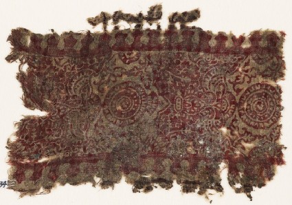 Textile fragment with ornate plants, leaves, and circlesfront