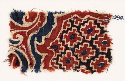 Textile fragment with stepped diamond-shapes and swirling plantsfront