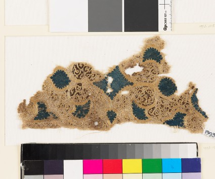 Textile fragment with swirling vegetal pattern and trefoil shapesfront