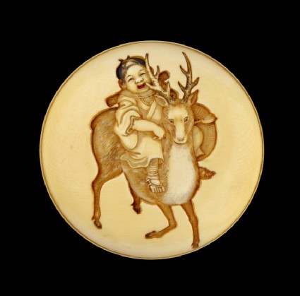 Manjū netsuke depicting a child riding a sacred deerfront