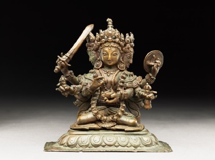 Seated figure of a multi-headed and multi-armed crowned female deityside