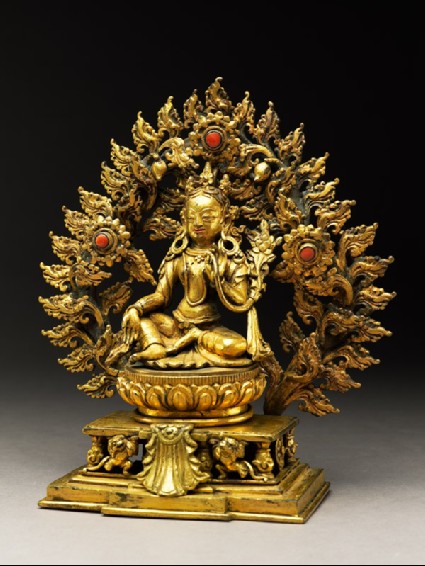 Seated figure of a female deity, possibly Tara, with a mandorla of flamesside