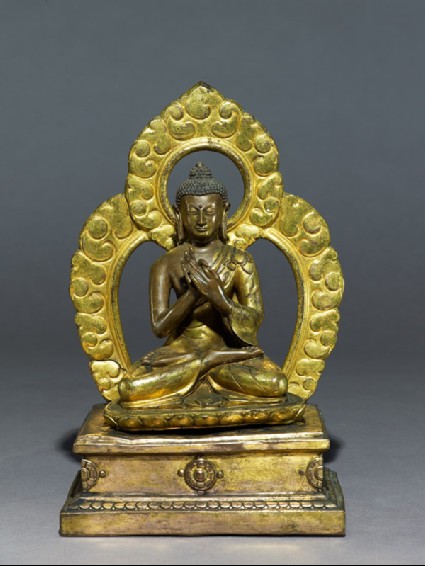 Seated figure of the Buddha with a mandalaside