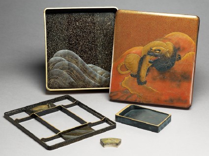 Writing box depicting a tiger on the lid, with a dragon and wave pattern insideoblique, open with contents