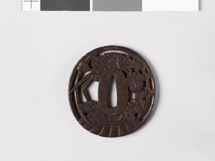 Tsuba in the form of a basket containing iris leaves and chrysanthemumsfront