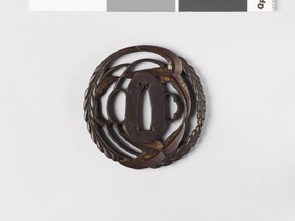 Round tsuba with arrowhead and Cissus leaves, and karakusa, or scrolling plant patternfront