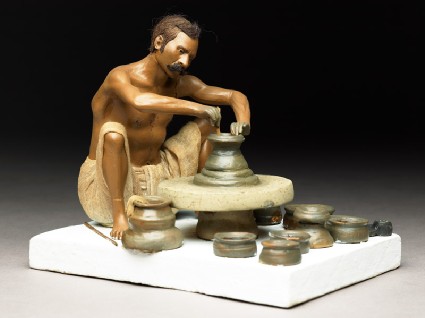 Model depicting a potter turning a pot on a wheelside