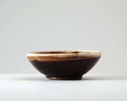 Black ware bowl with russet iron splashes and a white rimfront