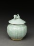 Lidded white ware jar surmounted by bird (oblique)