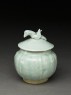 Lidded white ware jar surmounted by bird (oblique)