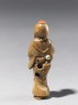 Netsuke in the form of a figure wearing a mask of Okame, a merry Shinto goddess (side)