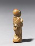 Netsuke in the form of a figure wearing a mask of Okame, a merry Shinto goddess (side)