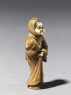 Netsuke in the form of a figure wearing a mask of Okame, a merry Shinto goddess (side)