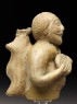 Figure of a musician carrying a water-skin (side)