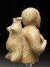 Figure of a musician carrying a water-skin (side)