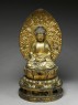 Figure of the Buddha with a mandorla, or halo, seated on a lotus pedestal (oblique)