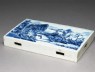 Blue-and-white tile with a landscape on one side and flowers on the other (oblique)