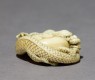 Netsuke in the form of a dragon coiled around a bowl (oblique)