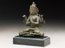 Seated figure of a crowned deity with four arms upon another figure (side)