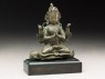 Seated figure of a crowned deity with four arms upon another figure (side)