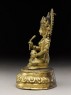 Seated figure of a deity holding a spoon and pot (side)