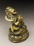 Seated figure of a male deity holding a bell and vajra, his head cocked back and mouth open, possibly an incense burner or pill dispenser (side)