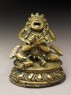 Seated figure of a male deity holding a bell and vajra, his head cocked back and mouth open, possibly an incense burner or pill dispenser (side)