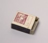 Matchbox depicting a figure reading (oblique)