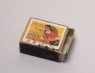 Matchbox depicting a woman holding a sickle (oblique)