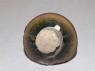 Black ware tea bowl with 'hare's fur' glazes, stuck to a firing pad (bottom)