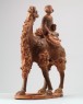 Figure of a camel carrying a young girl (oblique)